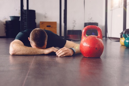 man falls at the gym and feels embarrassed